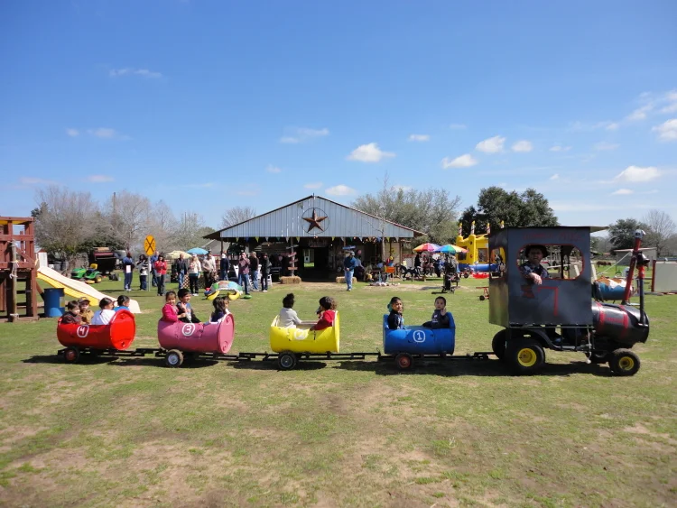 The colorful trackless train in front of the party barn