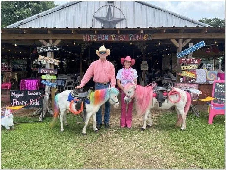 Cowboy Mike and Cowgirl Marian with their rainbow and pink ponies outside the Hitchin’ Post barn